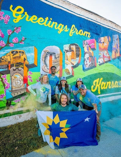 greater topeka partnership in front of topeka mural