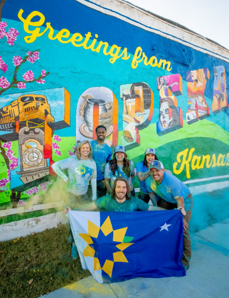 people posed in front of a mural in topeka, kansas